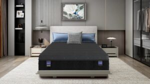 Modern contemporary bedroom with gray upholstered headboard bed, blue pillows, and a black quilted mattress flanked by white nightstands and lamps; built-in wardrobe on right and a framed floral painting above the bed.